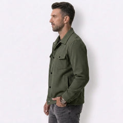 Man wearing MannerCo dark brown corduroy single-breasted lapel jacket, side view on plain background