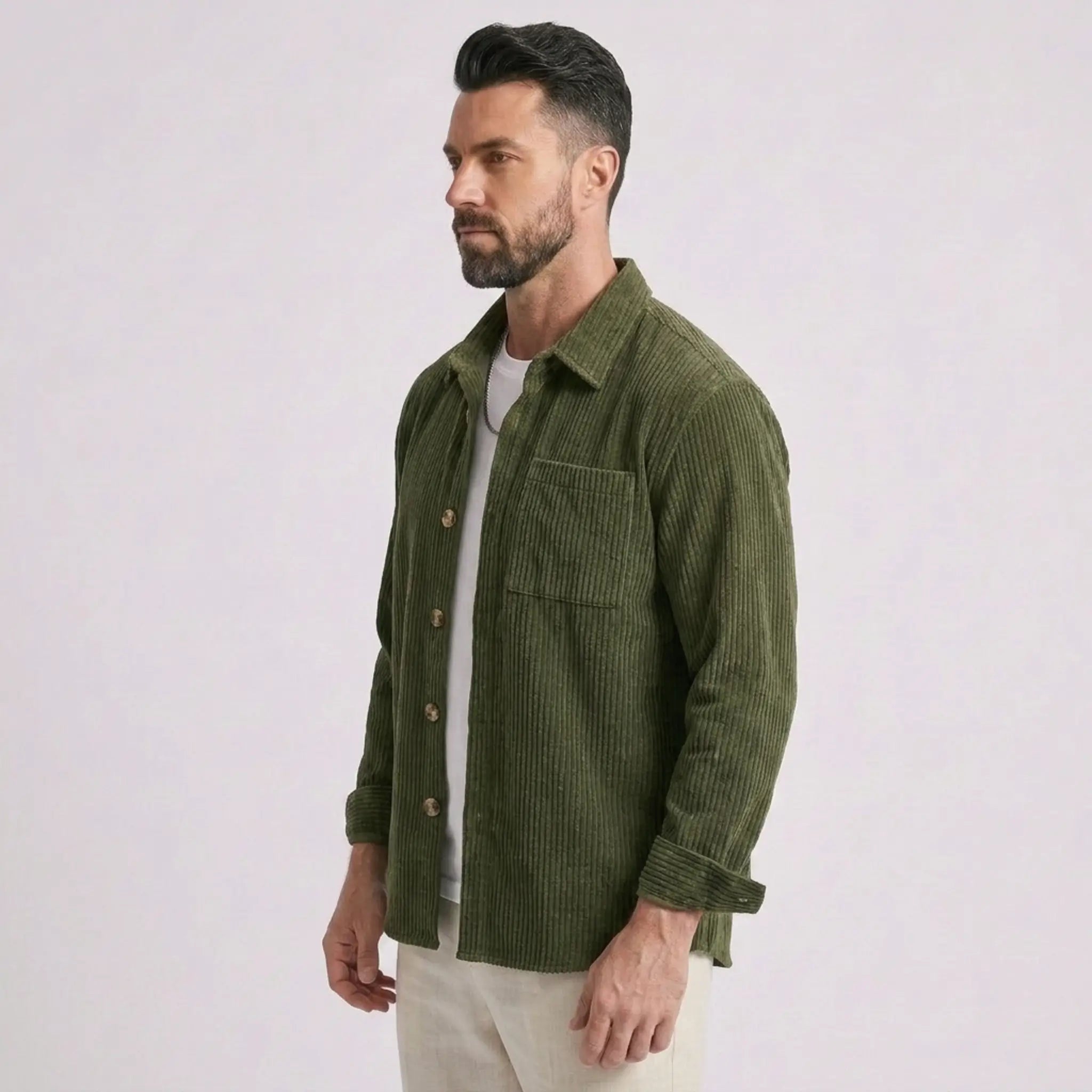 Man wearing MannerCo green corduroy long sleeve shirt, side view on plain background