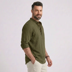 Man wearing MannerCo army green cotton linen long sleeve Henley shirt, back view on plain background