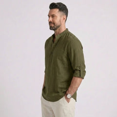 Man wearing MannerCo army green cotton linen long sleeve Henley shirt, side view on plain background