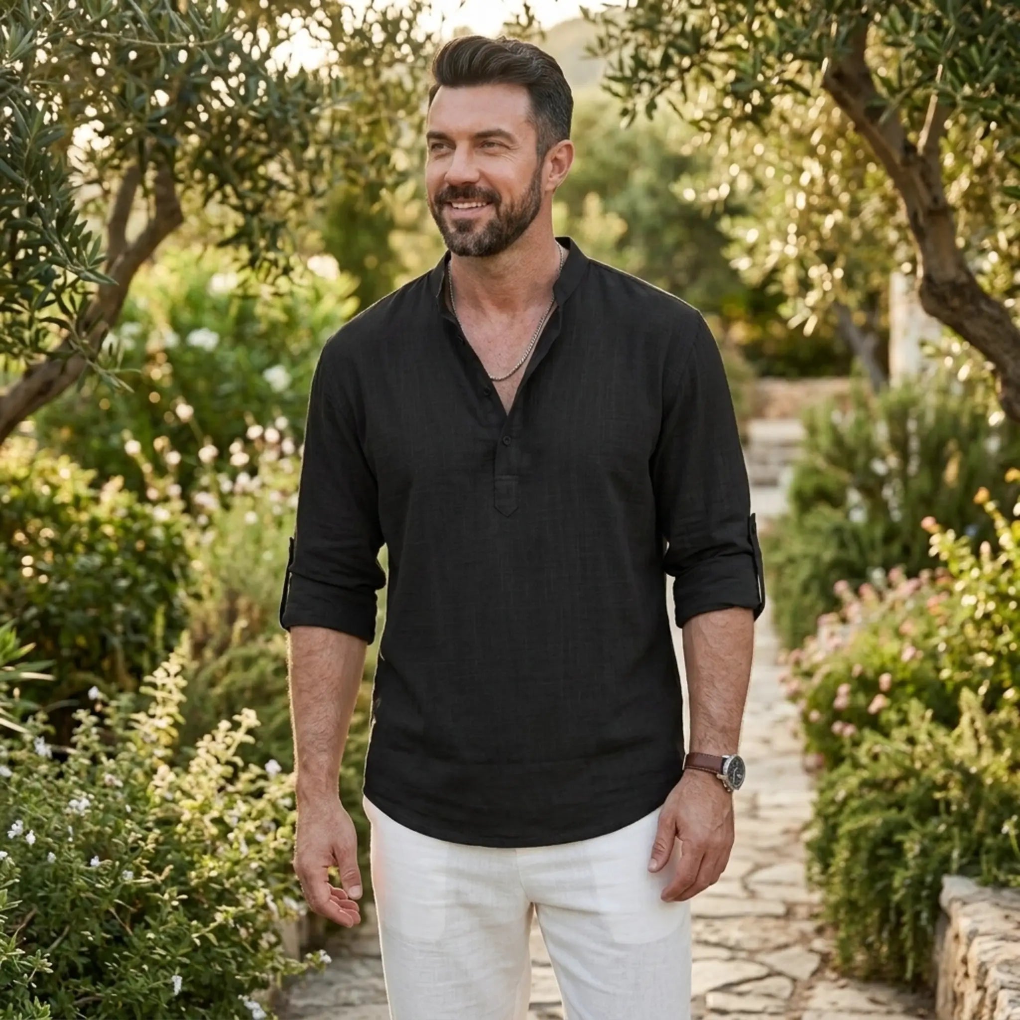 Man wearing MannerCo black cotton linen Henley shirt in outdoor lifestyle setting