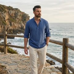 Man wearing MannerCo denim blue cotton linen long sleeve Henley shirt, back view on plain background