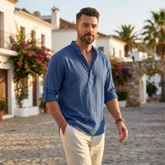 Man wearing MannerCo denim blue cotton linen Henley shirt in outdoor lifestyle setting