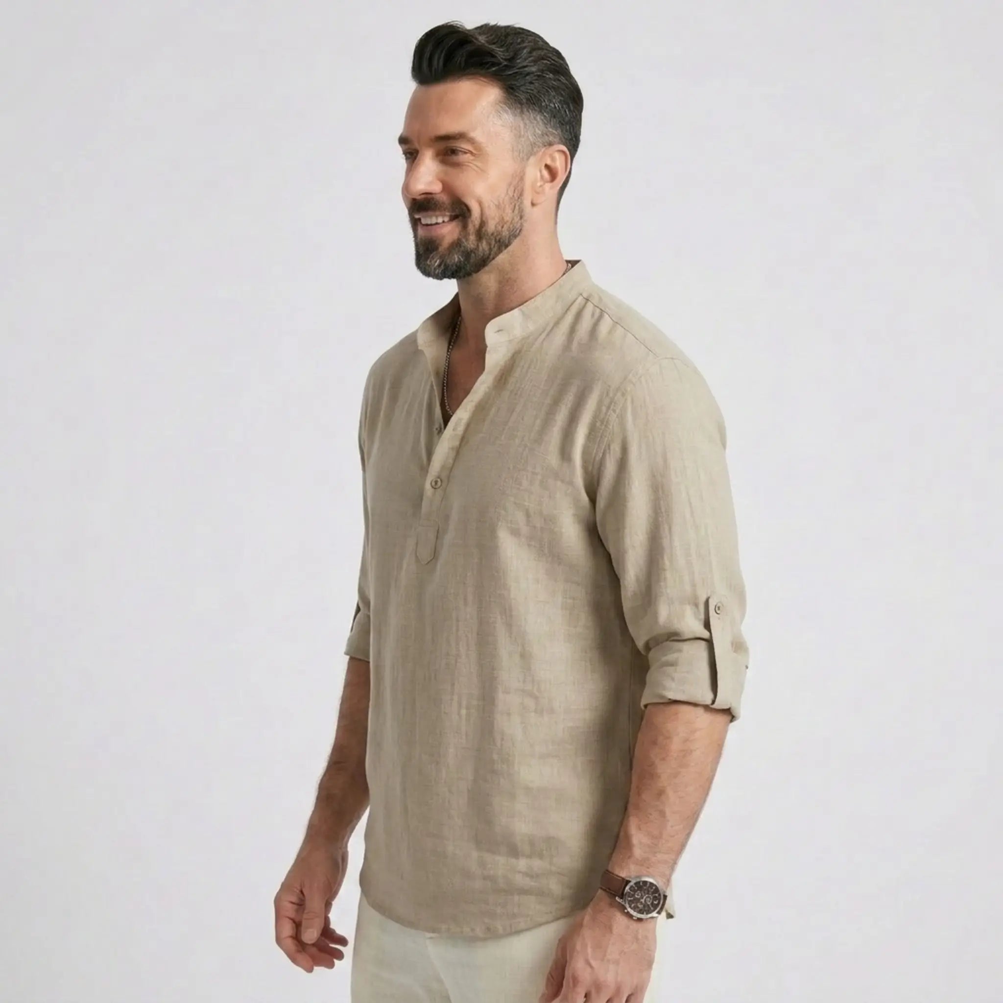 Man wearing MannerCo khaki cotton linen long sleeve Henley shirt, side view on plain background