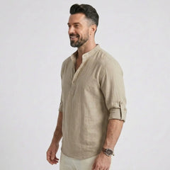 Man wearing MannerCo khaki cotton linen long sleeve Henley shirt, side view on plain background