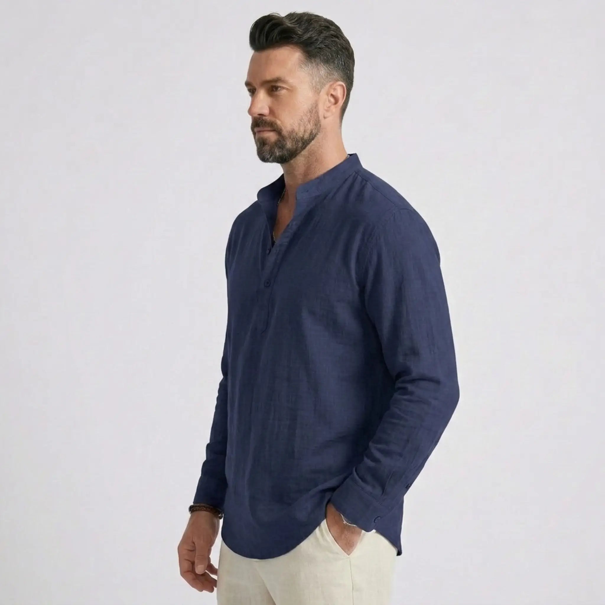 Man wearing MannerCo navy cotton linen long sleeve Henley shirt, back view on plain background