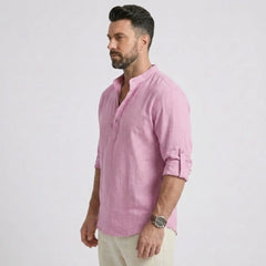 Man wearing MannerCo white cotton linen long sleeve Henley shirt, side view on plain background