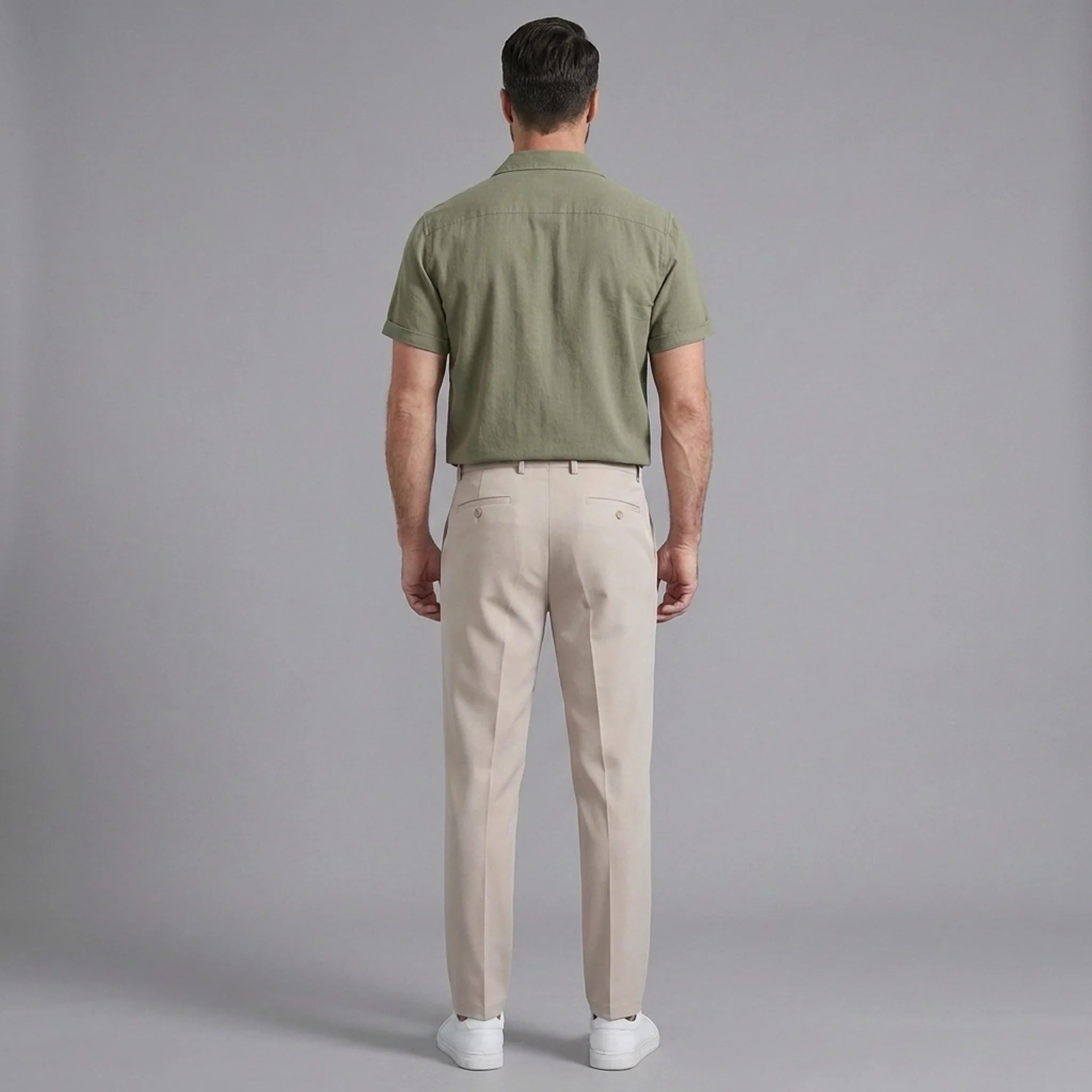 Back view of man wearing dark green linen Cuban collar shirt and slim fit tapered trousers