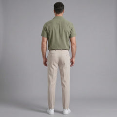 Back view of man wearing dark green linen Cuban collar shirt and slim fit tapered trousers
