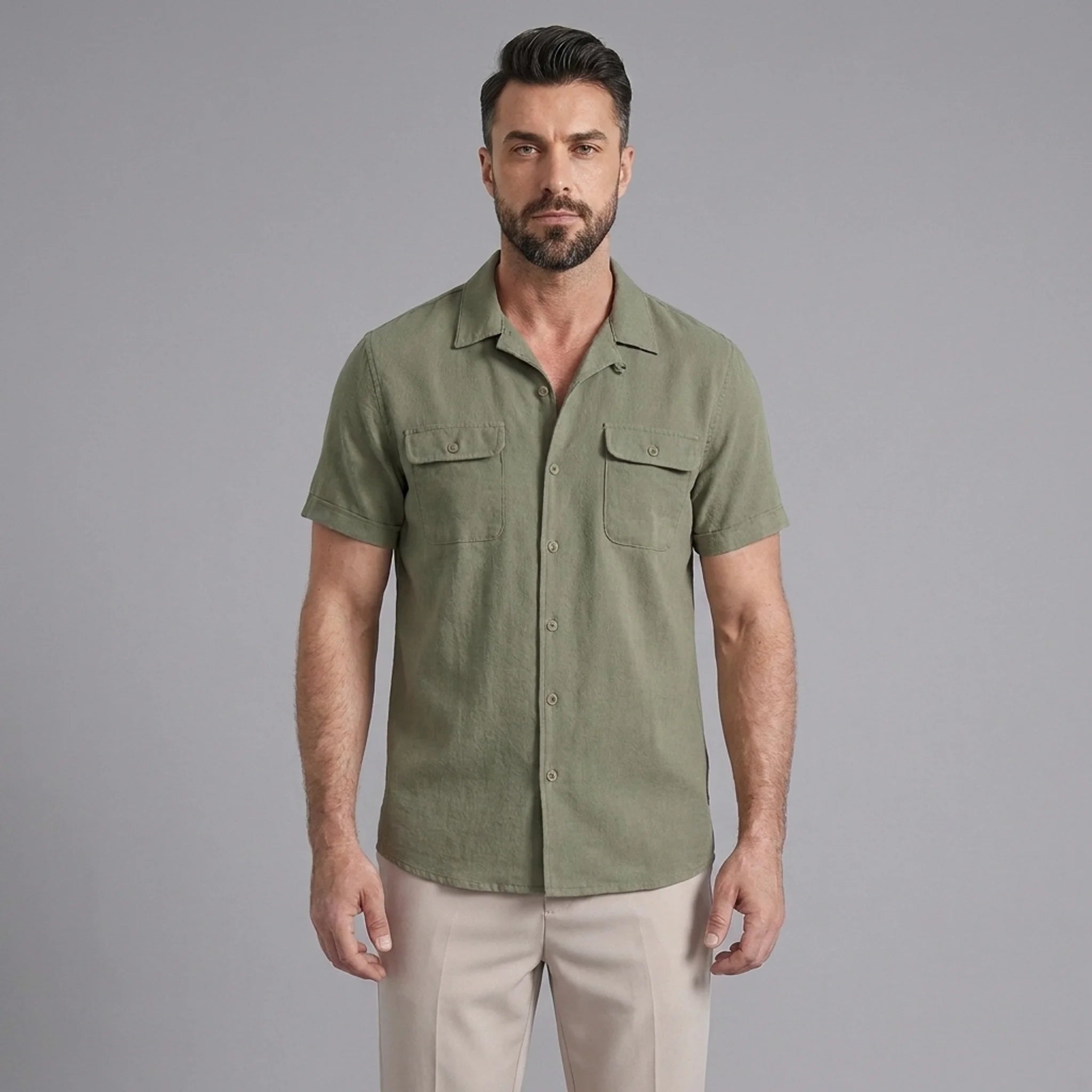 Three quarter view of man in dark green linen Cuban collar shirt and slim fit tapered trousers