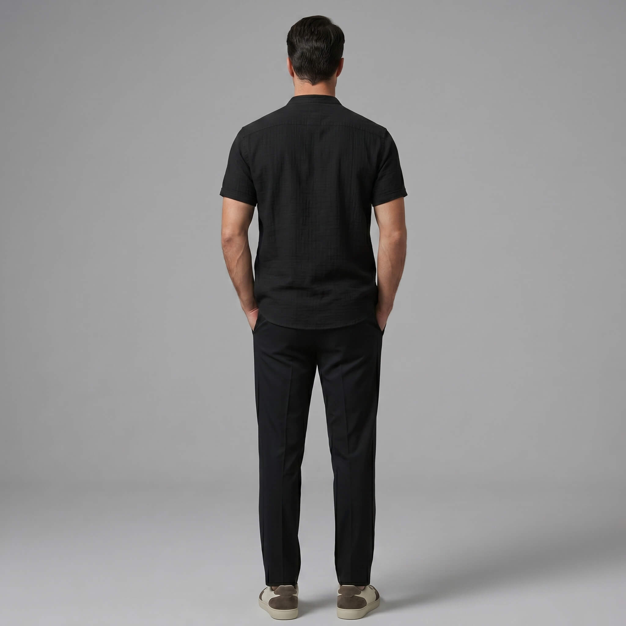 Back view of man wearing dark green linen look stand collar shirt and slim fit tapered trousers