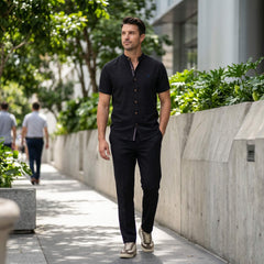 Man in dark green linen look stand collar shirt and tapered trousers in sunny outdoor scene