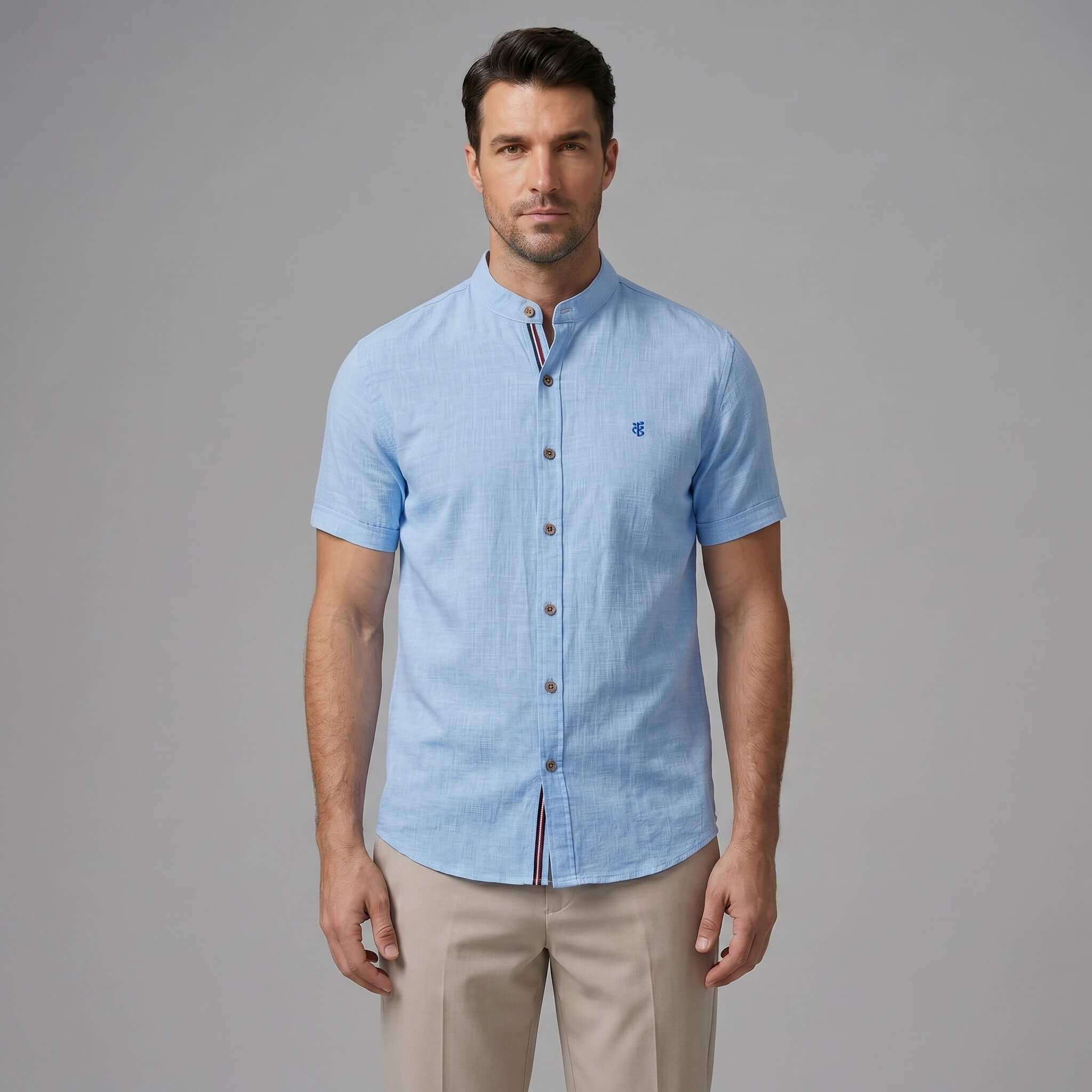Man wearing dark green linen look stand collar shirt and slim tapered trousers relaxing outdoors