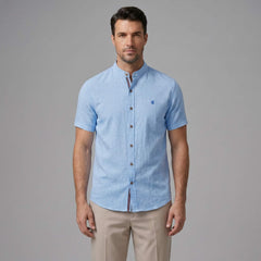 Man wearing dark green linen look stand collar shirt and slim tapered trousers relaxing outdoors