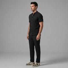 Side view of man in dark green linen look stand collar shirt and slim tapered trousers