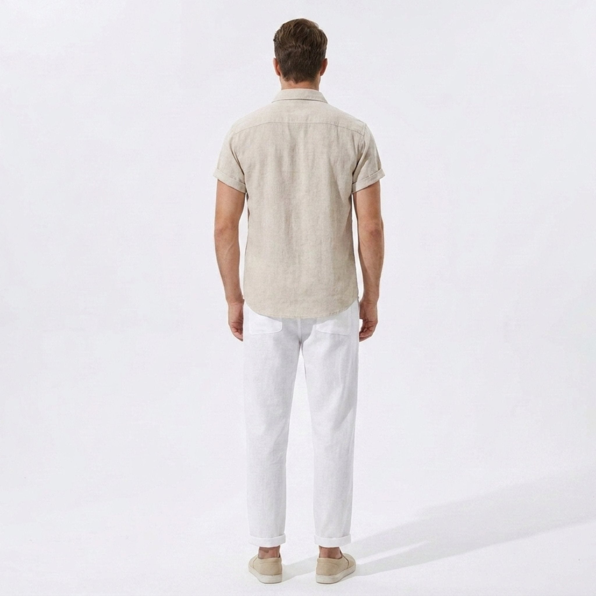 Back view of man wearing dark green linen rayon blend utility shirt and linen pants