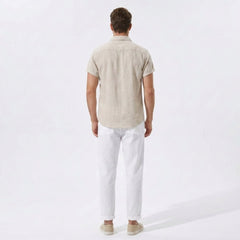 Back view of man wearing dark green linen rayon blend utility shirt and linen pants