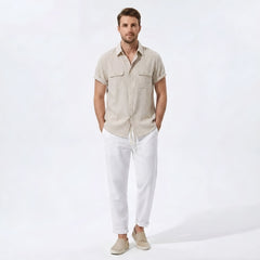 Man wearing dark green linen rayon blend pocket utility shirt and straight leg linen pants front view