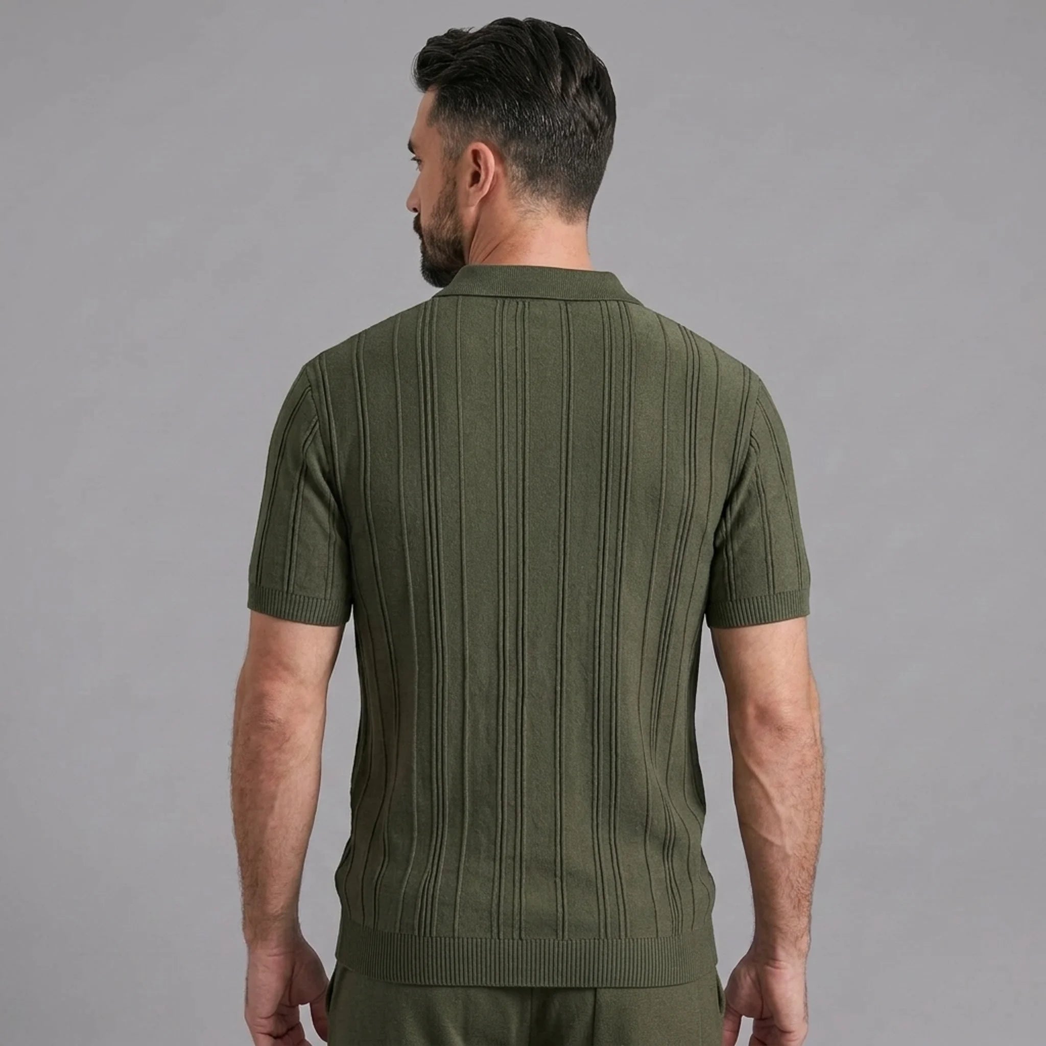 Back view of man wearing dark green stripe jacquard knit zip-up polo shirt