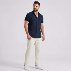 Full length view of man in dark green waffle button up shirt and straight leg linen pants