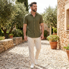Man wearing dark green waffle button up shirt and linen pants in outdoor lifestyle setting