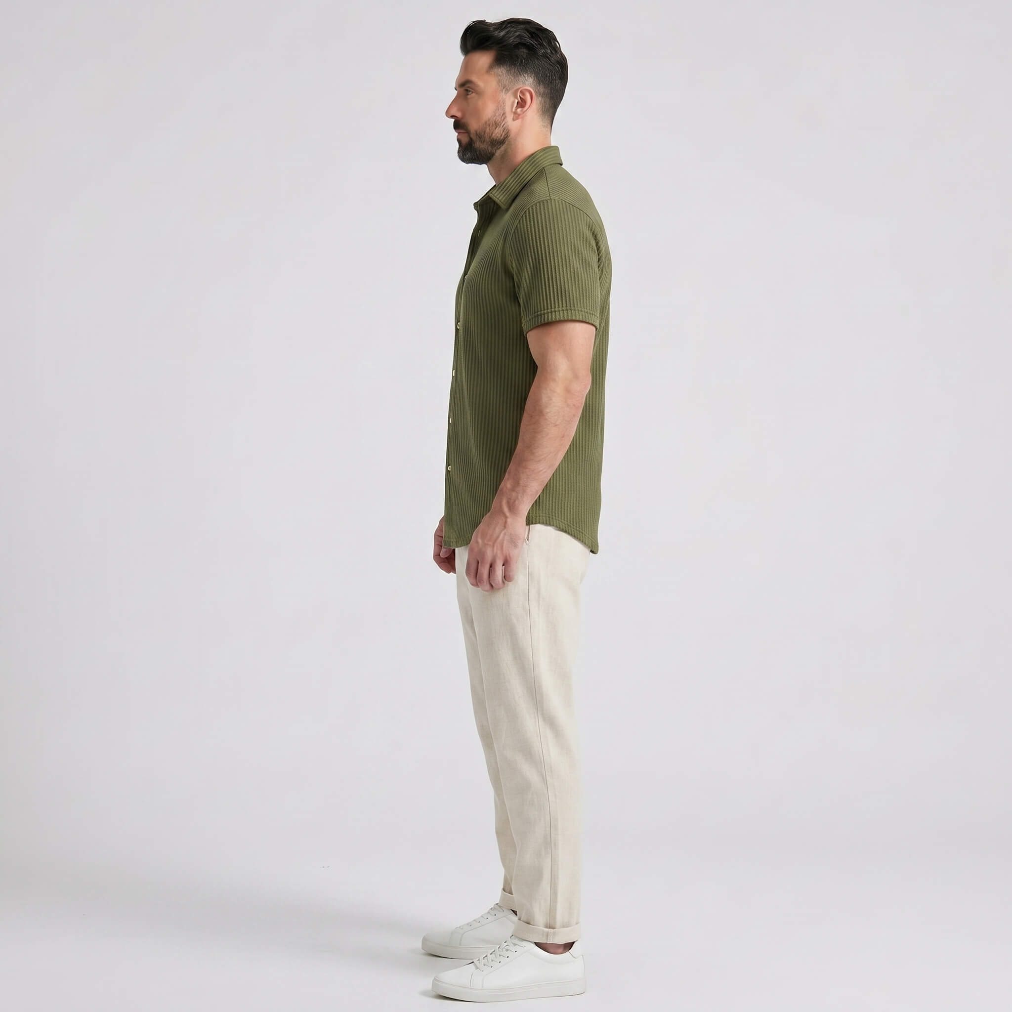 Side view of man in dark green waffle button up shirt and straight leg linen pants