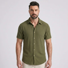 Three quarter view of man in dark green waffle button up shirt and straight leg linen pants