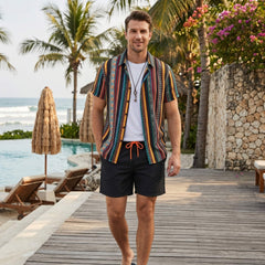 Man wearing colorful ethnic geometric print shirt and swim shorts in outdoor lifestyle setting