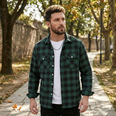 MannerCo green plaid flannel shirt with turn-down collar worn open over white tee outdoors