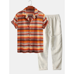 Short-sleeve patterned shirt and white pants on a hanger against a white background