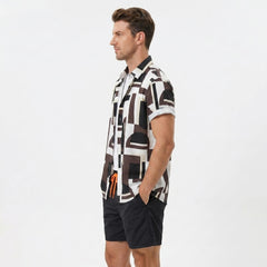 Side view of man in geometry colorblock print button up shirt and swim shorts on plain background