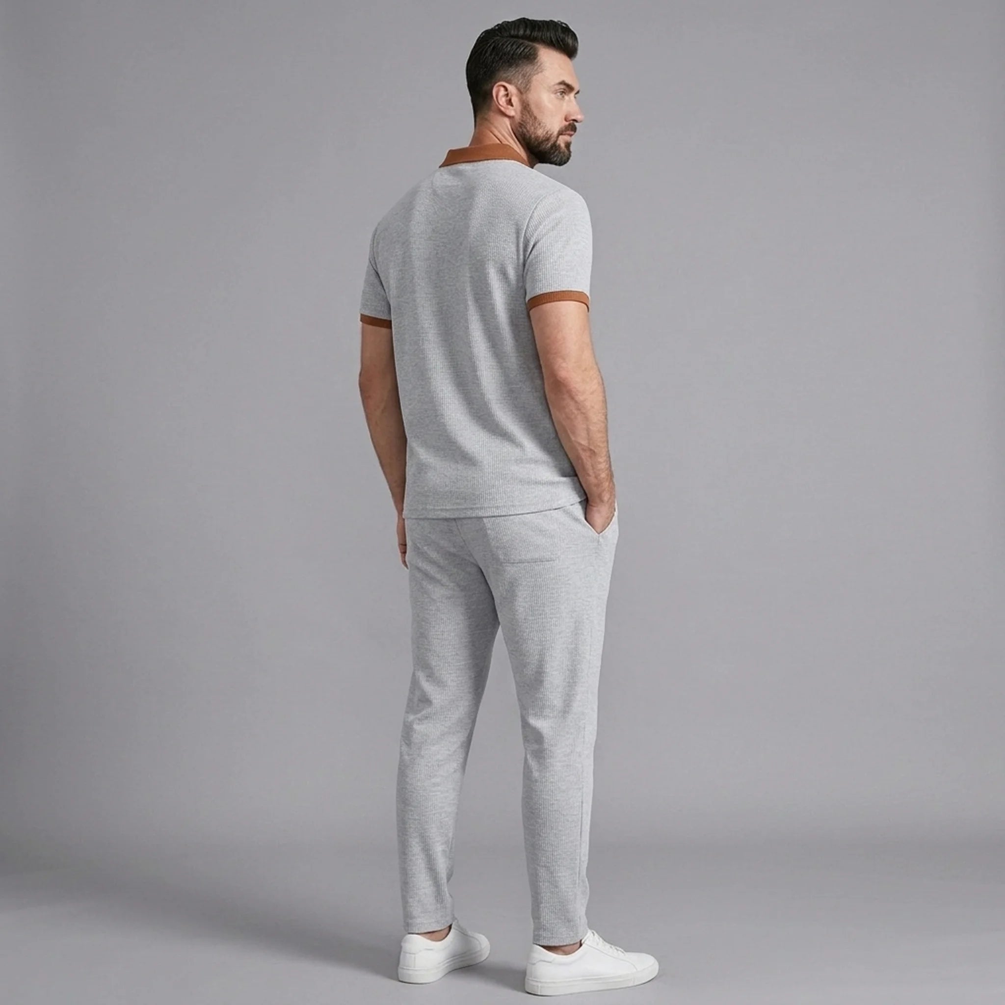 Man wearing gray color block waffle polo and straight leg pants outdoor lifestyle setting