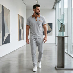 Man in gray color block waffle polo and straight leg pants in sunny outdoor scene
