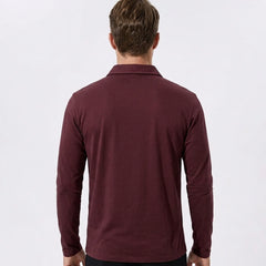 Man wearing gray solid long sleeve cotton polo shirt in outdoor lifestyle setting