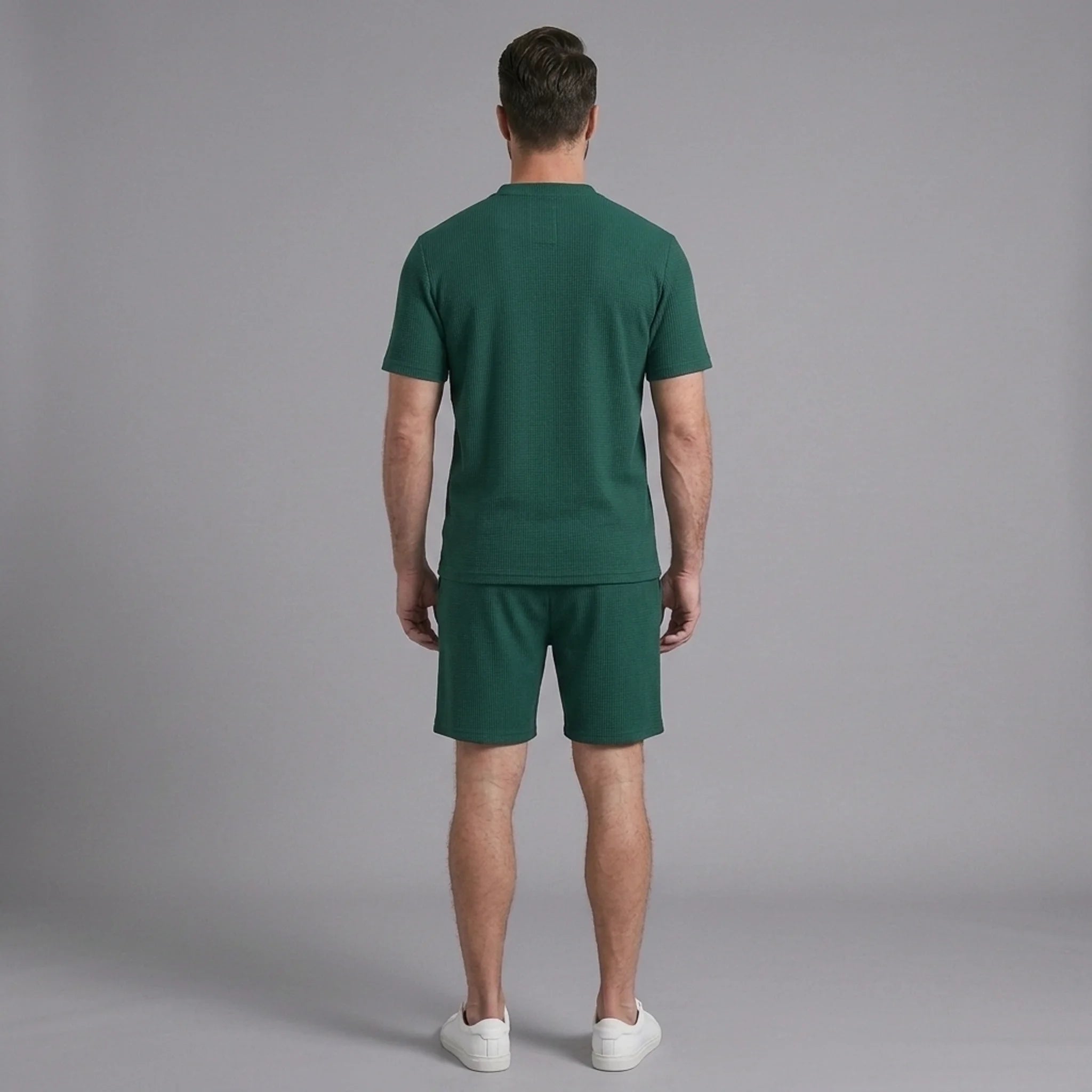 Back view of man wearing green waffle stand collar shirt and drawstring shorts