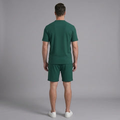 Back view of man wearing green waffle stand collar shirt and drawstring shorts