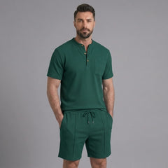 Man wearing a green waffle stand collar button up shirt and drawstring shorts front view
