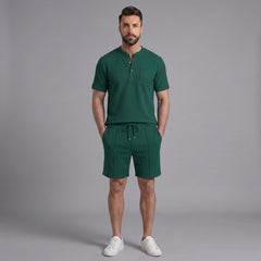 Man wearing green waffle stand collar shirt and drawstring shorts in outdoor lifestyle setting
