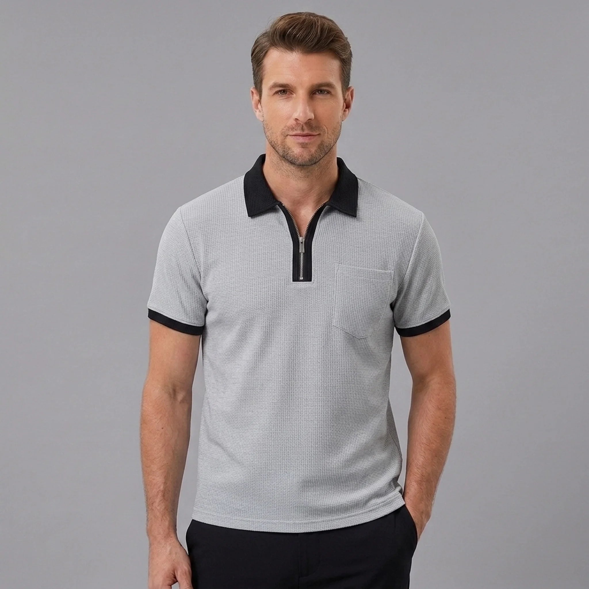 Side view of man in grey color block waffle polo shirt on plain background
