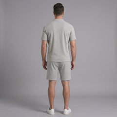 Back view of man wearing grey waffle stand collar shirt and drawstring shorts