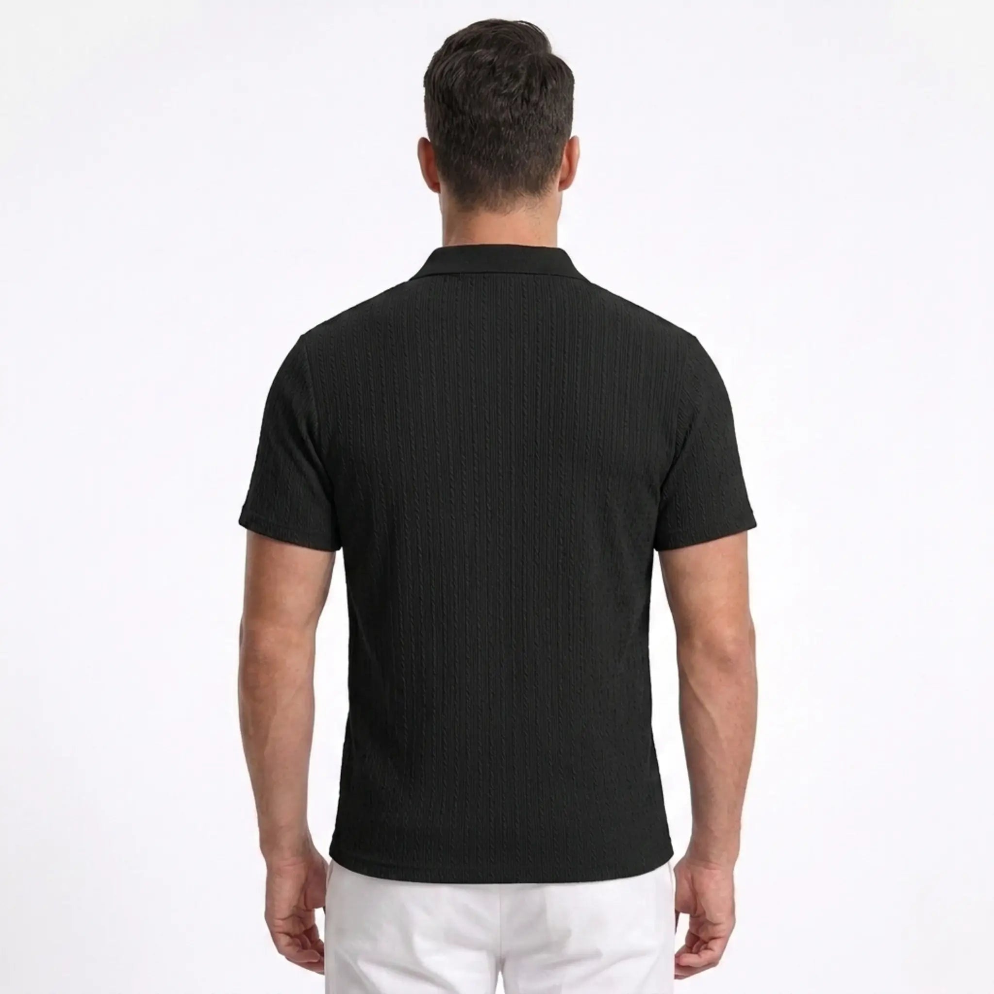 Man wearing MannerCo black jacquard knit polo shirt in outdoor lifestyle setting