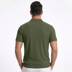 Man wearing MannerCo khaki jacquard knit polo shirt in outdoor lifestyle setting