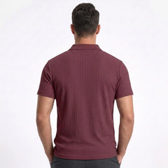 Man wearing MannerCo military green jacquard knit polo shirt in outdoor lifestyle setting