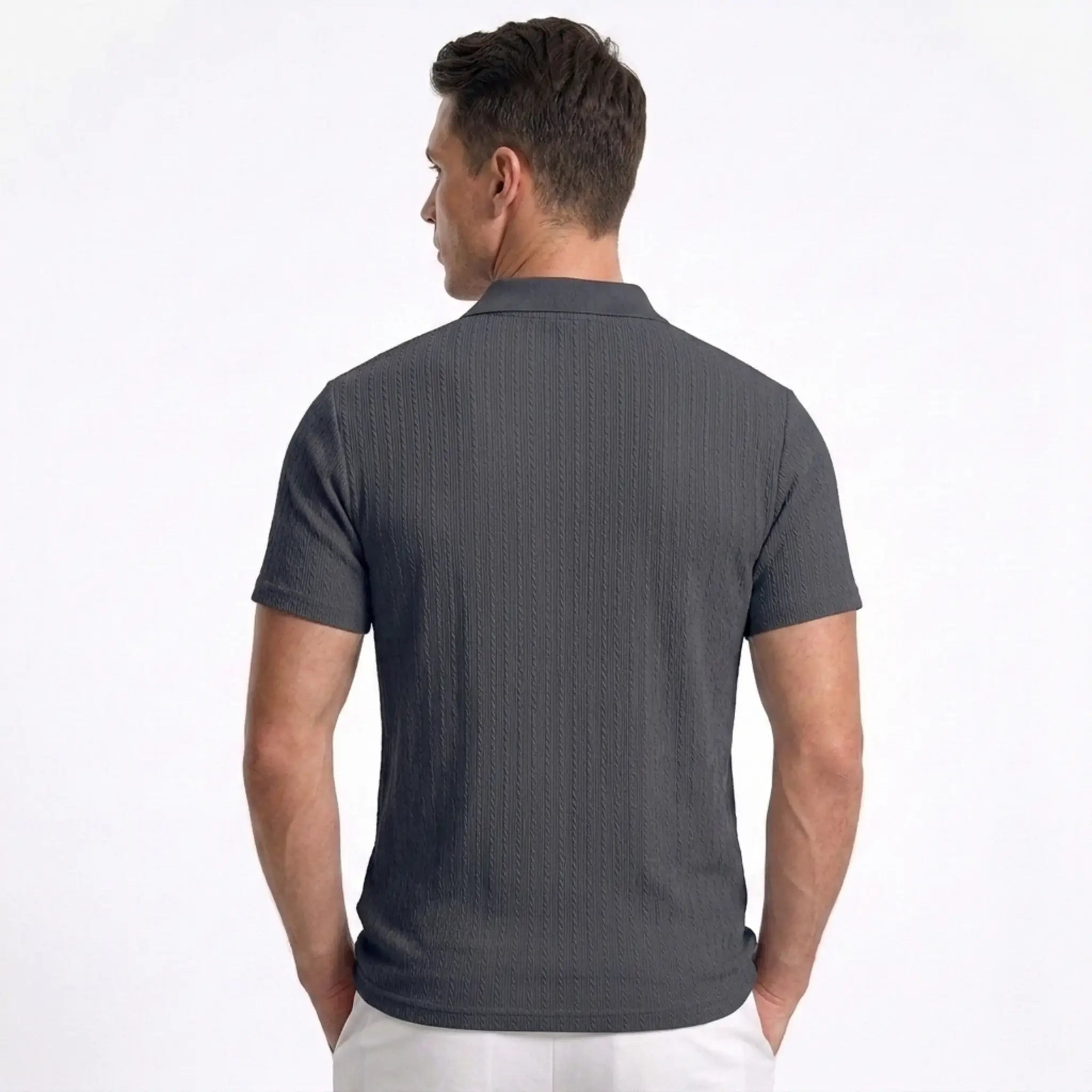 Man wearing MannerCo navy blue jacquard knit polo shirt in outdoor lifestyle setting