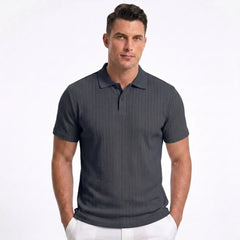 Man wearing MannerCo navy blue jacquard knit polo shirt in outdoor lifestyle setting