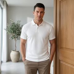 Man wearing MannerCo white jacquard knit polo shirt in outdoor urban lifestyle setting