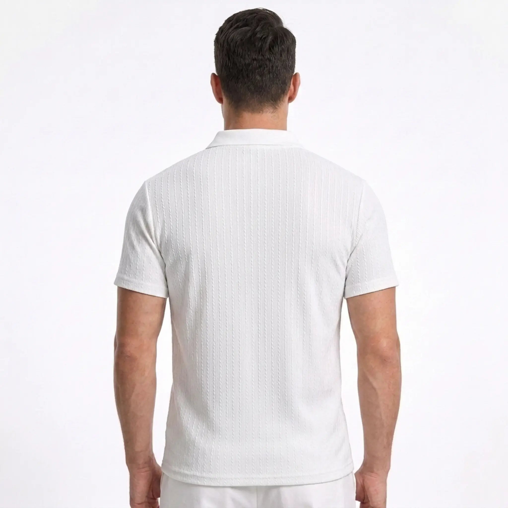 Man wearing MannerCo white jacquard knit polo shirt in sunny outdoor lifestyle setting