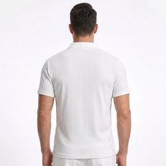 Man wearing MannerCo white jacquard knit polo shirt in sunny outdoor lifestyle setting