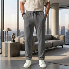 Man wearing MannerCo army green jacquard ribbed drawstring trousers in outdoor lifestyle setting
