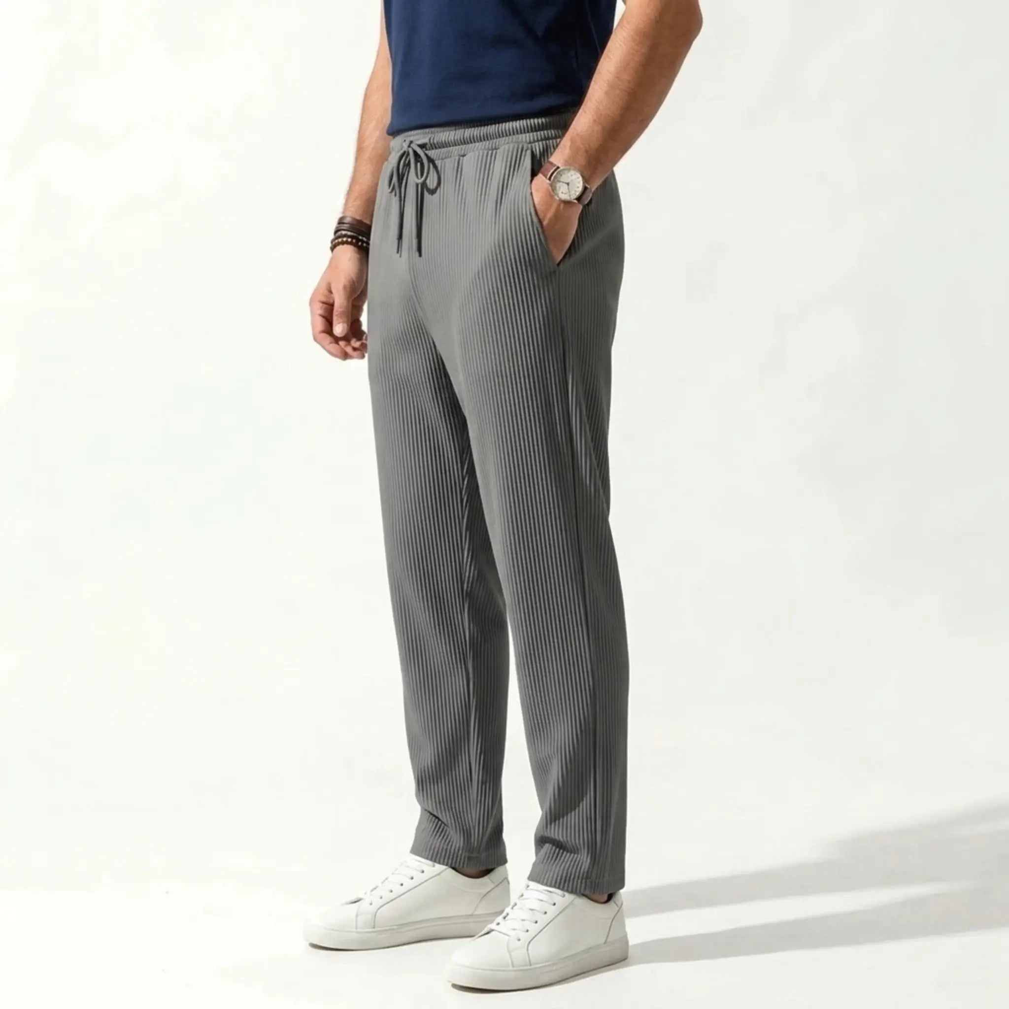 Man wearing MannerCo army green jacquard ribbed drawstring trousers, side view on plain background
